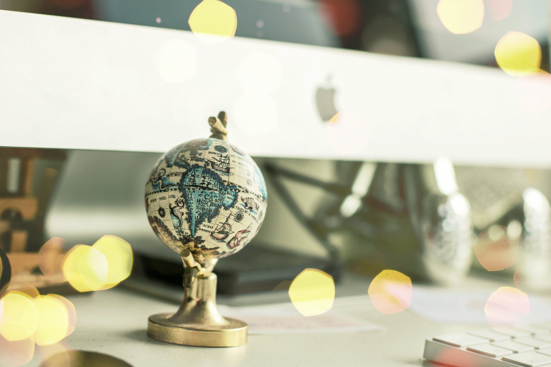 A small desk globe in close-up, lights blurred behind it.