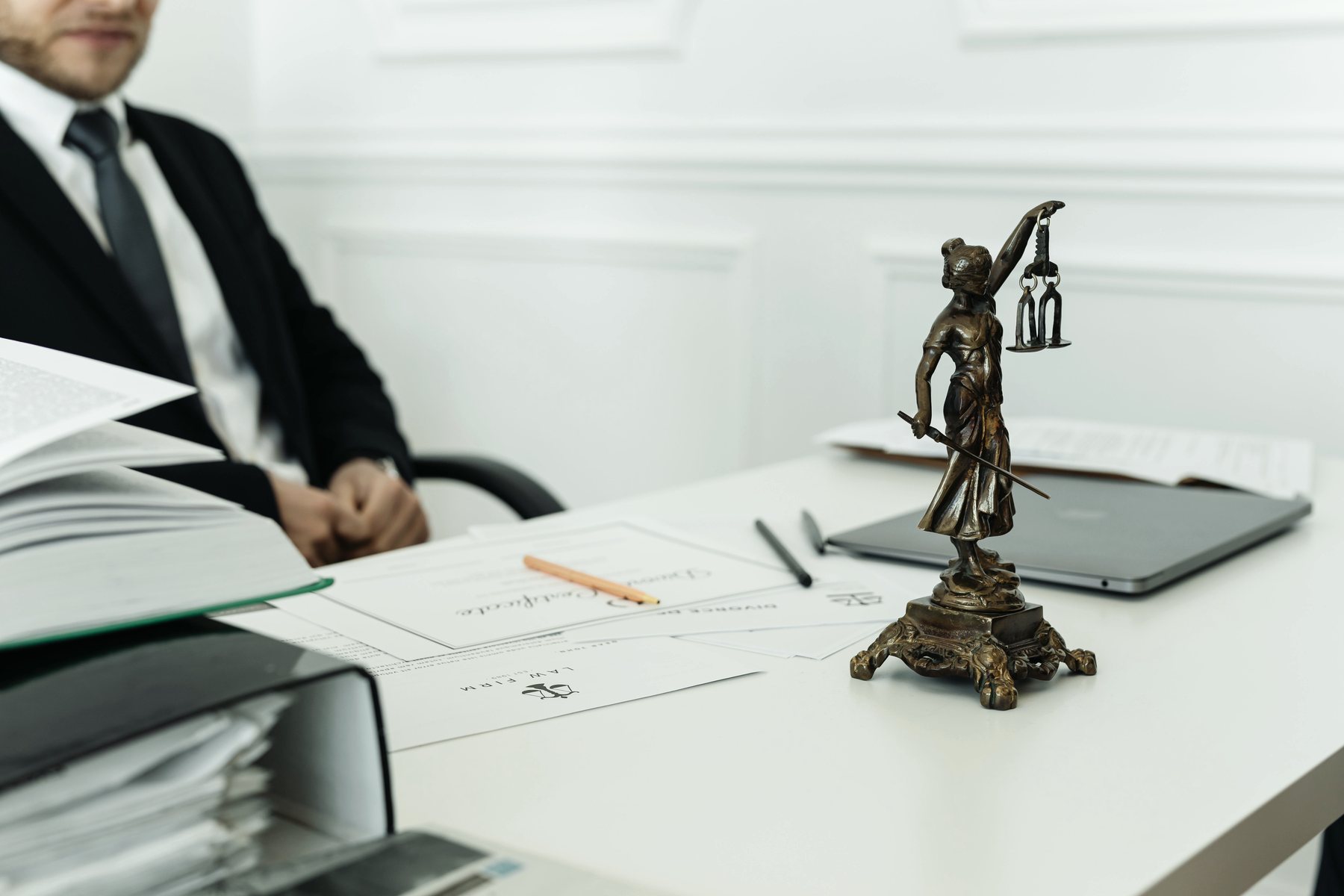 A lawyer’s desk with documents and a small figure of Lady Justice.
